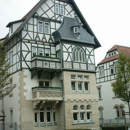 Historisches Fachwerkhaus mit aufwendigem Fassadendekor, Verzierungen und weißen Fenstern im denkmalgeschützten Stil.
