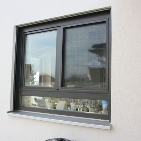 Modernes Schiebefenster: Nahaufnahme eines rechteckigen Fensters mit schwarzem Rahmen und verschiebbarer Scheibe.