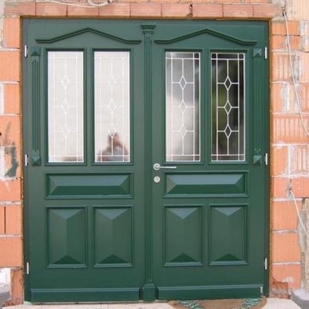 Grüne Haustür mit Zierverglasung: Klassische, grüne Haustür mit zwei Glaseinsätzen mit Bleiverglasung und zentralem Türgriff, noch im Rohbauzustand eingebaut.
