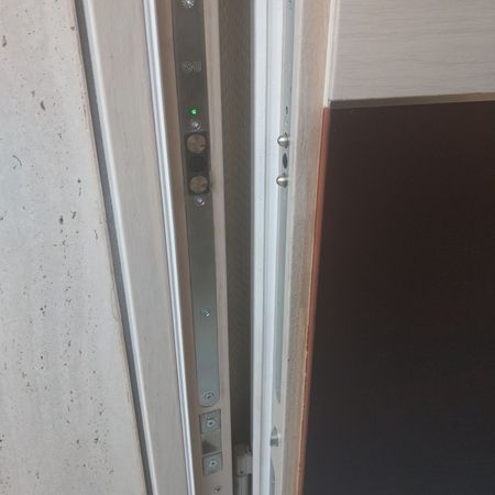 Elektronisches Türschloss im Detail: Nahaufnahme eines elektronischen Mehrfachverriegelungssystems mit LED-Anzeige in moderner Haustürzarge.